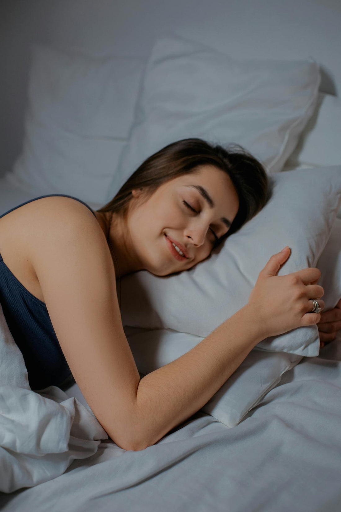 A woman sleeping on the bed with smile on her face