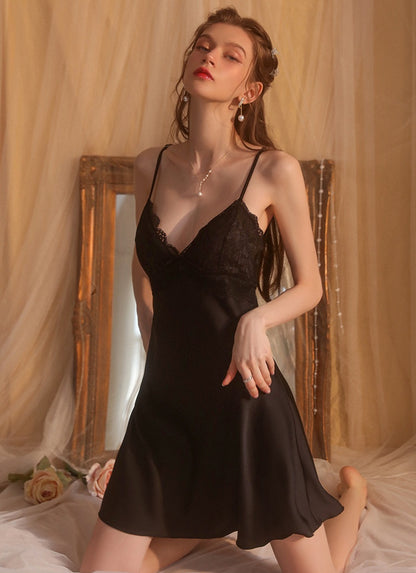 Woman wearing a black lace nightgown in a softly lit room.